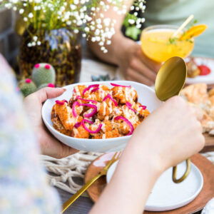 Kruidige bloemkoolroosjes met cheddarsaus en ingelegde ui