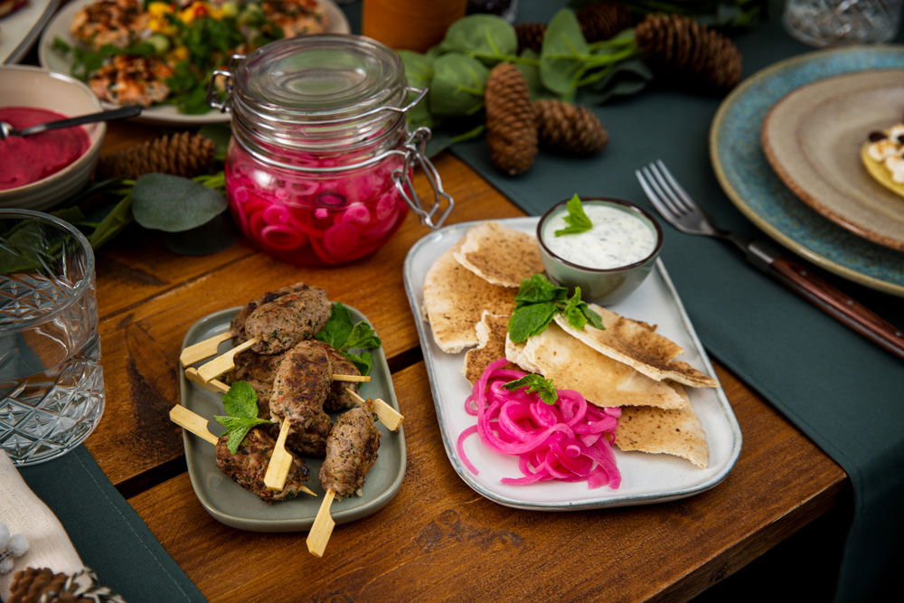 Lamsköfte met yoghurt-muntsaus, ingelegde ui en flatbread