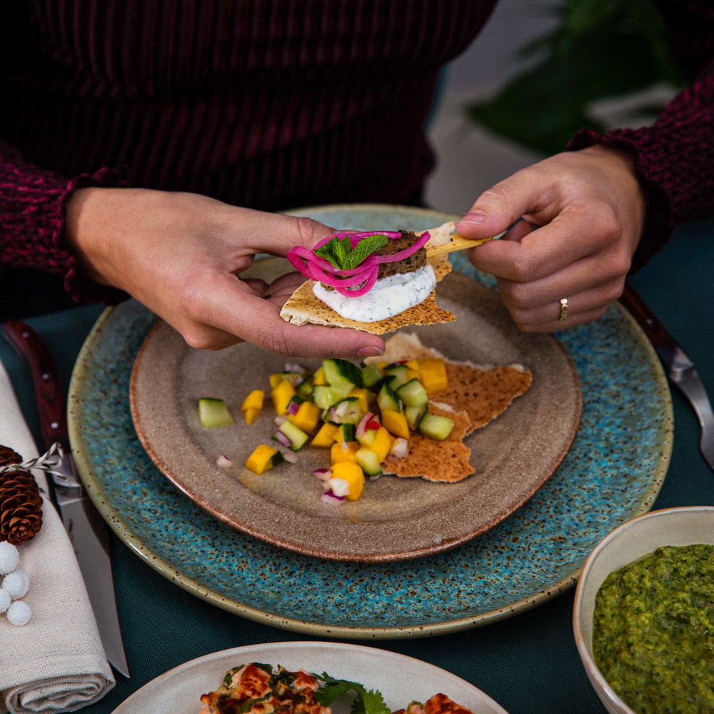 Lamsköfte met yoghurt-muntsaus, ingelegde ui en flatbread