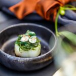 Amuse van coquille met wakame en geroosterde hazelnoten