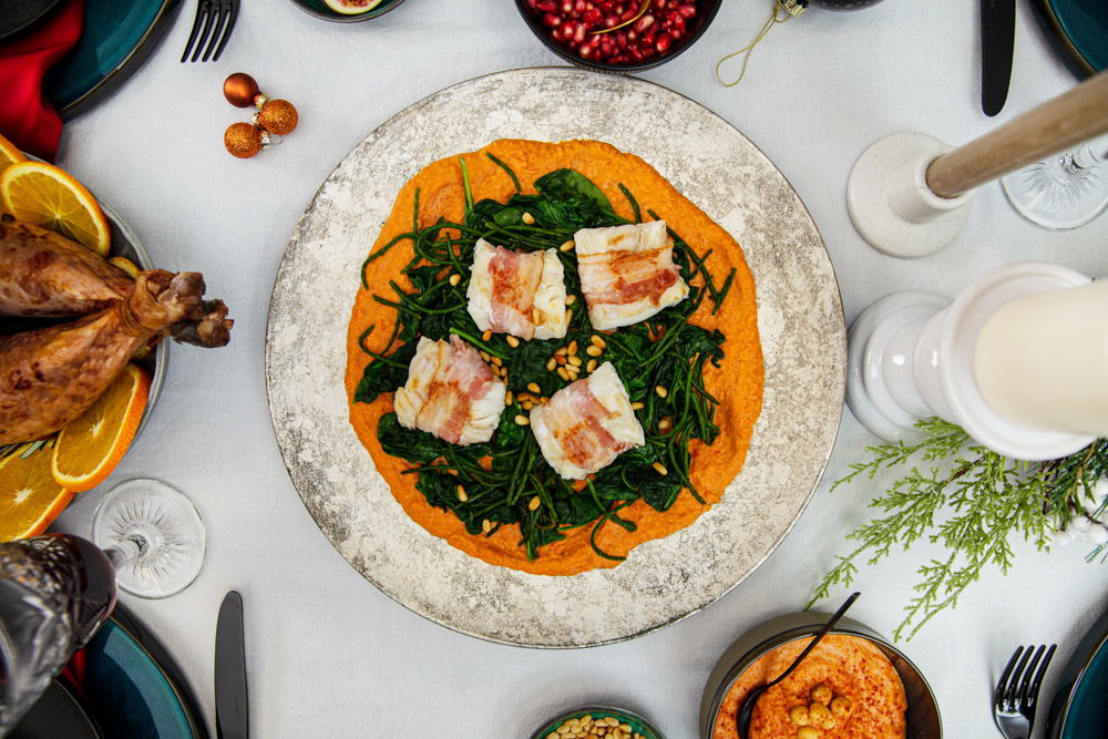 Kabeljauwhaas in spek met spicy hummus, spinazie en zeekraal