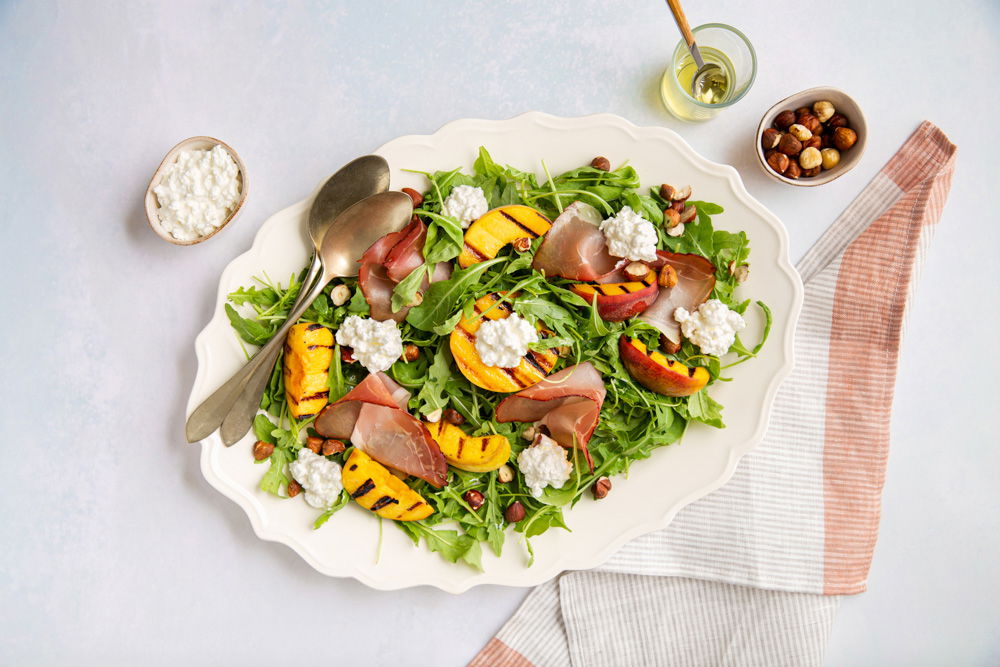 Rucolasalade met gegrilde perzik, rauwe ham en zelfgemaakte vinaigrette