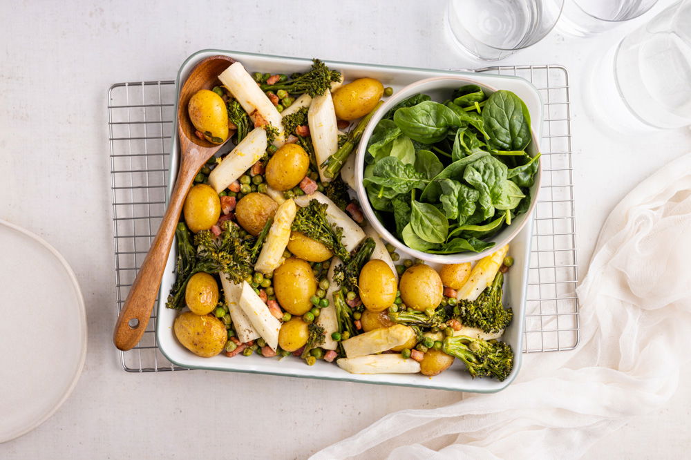 Witte asperges uit de oven met uitgebakken pancetta, doperwten en krieltjes