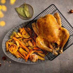 Hele gevulde kip met geroosterde bospeen en aardappelpartjes