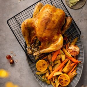 Hele gevulde kip met geroosterde bospeen en aardappelpartjes