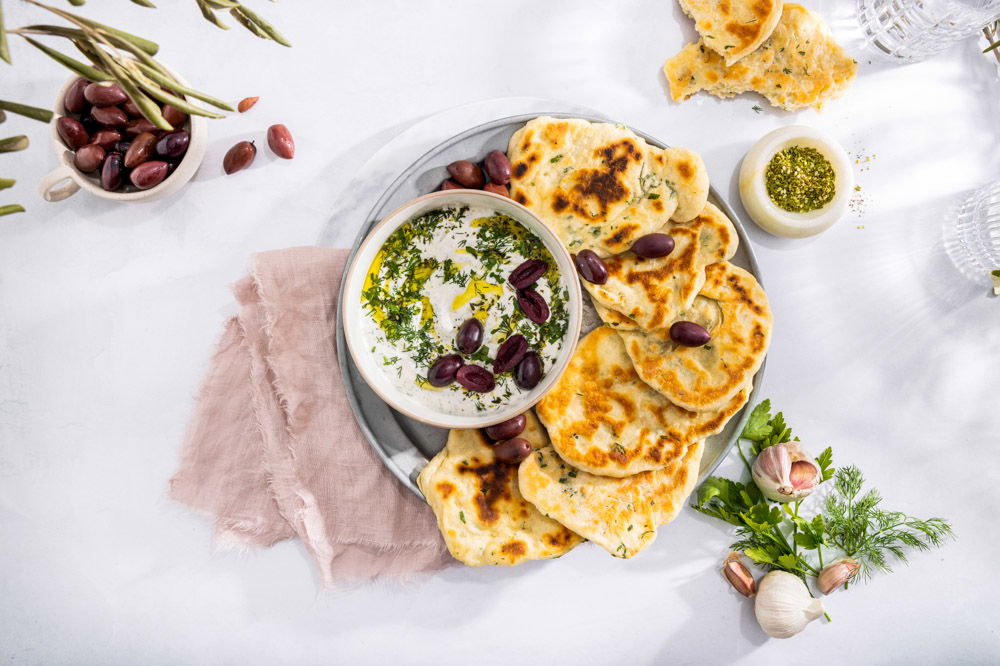 Zelfgemaakt flatbread met labneh en zwarte olijven