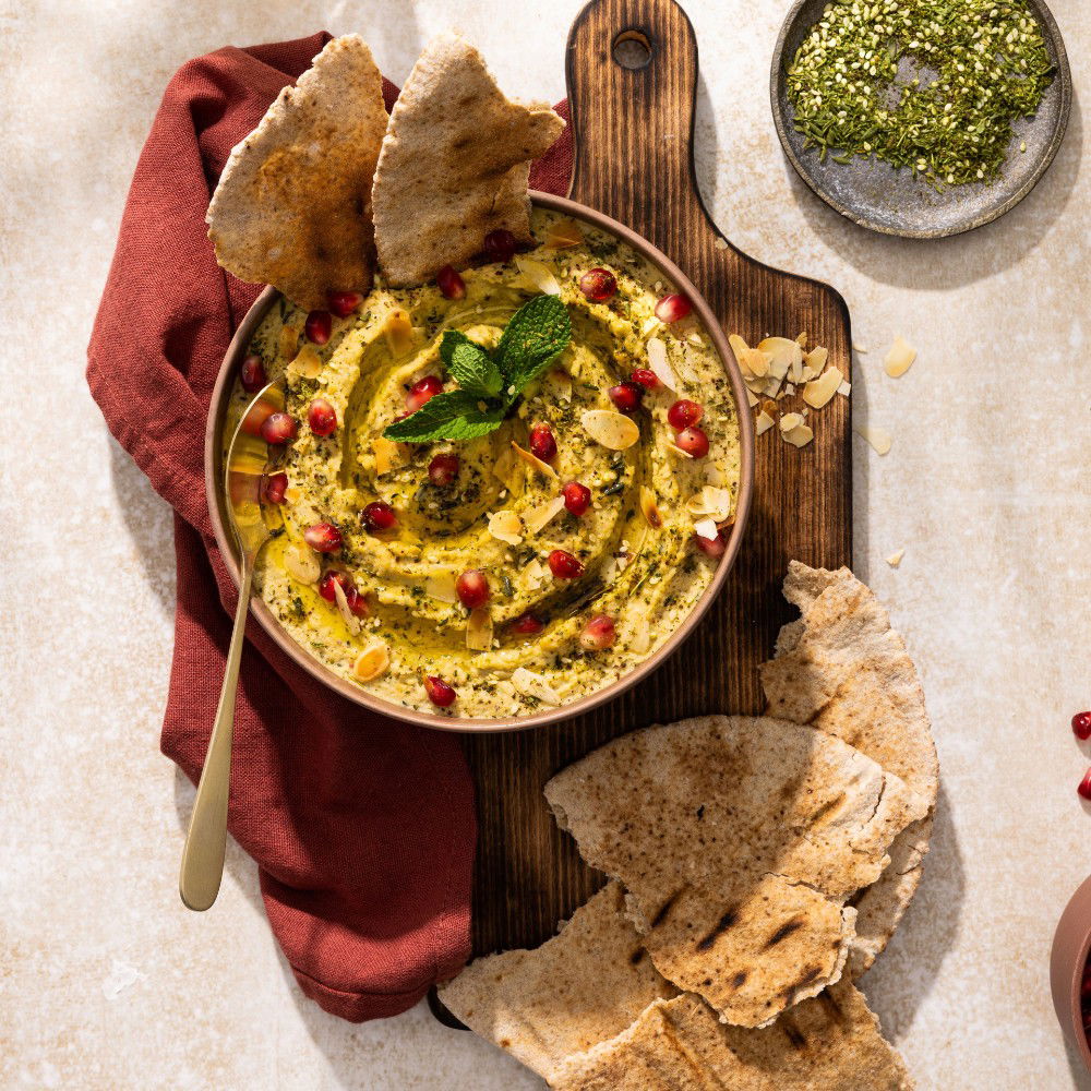 Hummus met za’atar, amandelschaafsel en granaatappelpitten