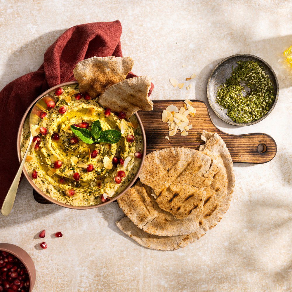 Hummus met za’atar, amandelschaafsel en granaatappelpitten