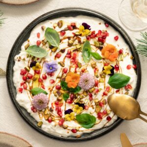 Stracciatella di burrata met granaatappel en bloemen