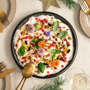 Stracciatella di burrata met granaatappel en bloemen