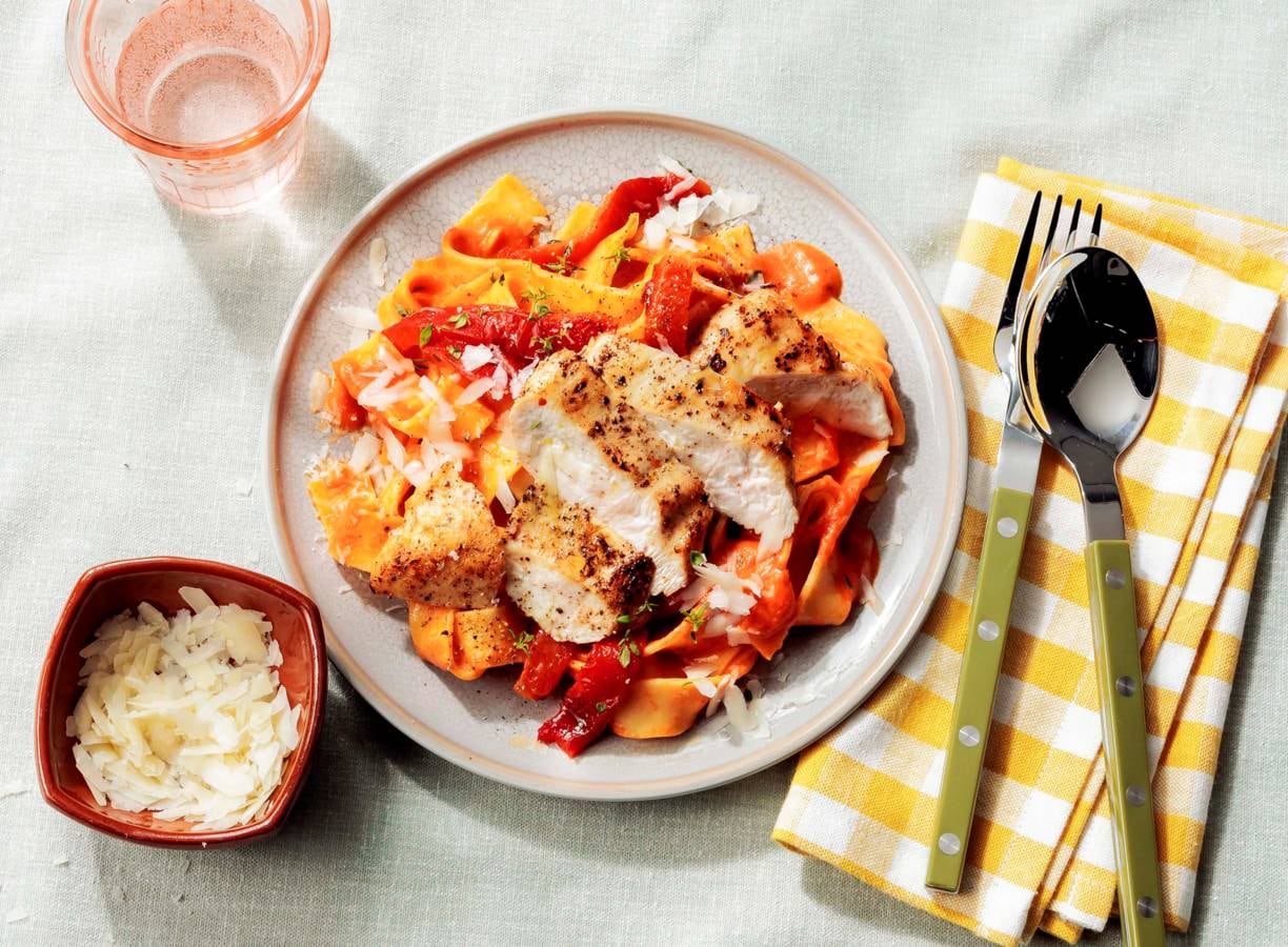Pappardelle met kip en gepofte-paprikasaus op een bord