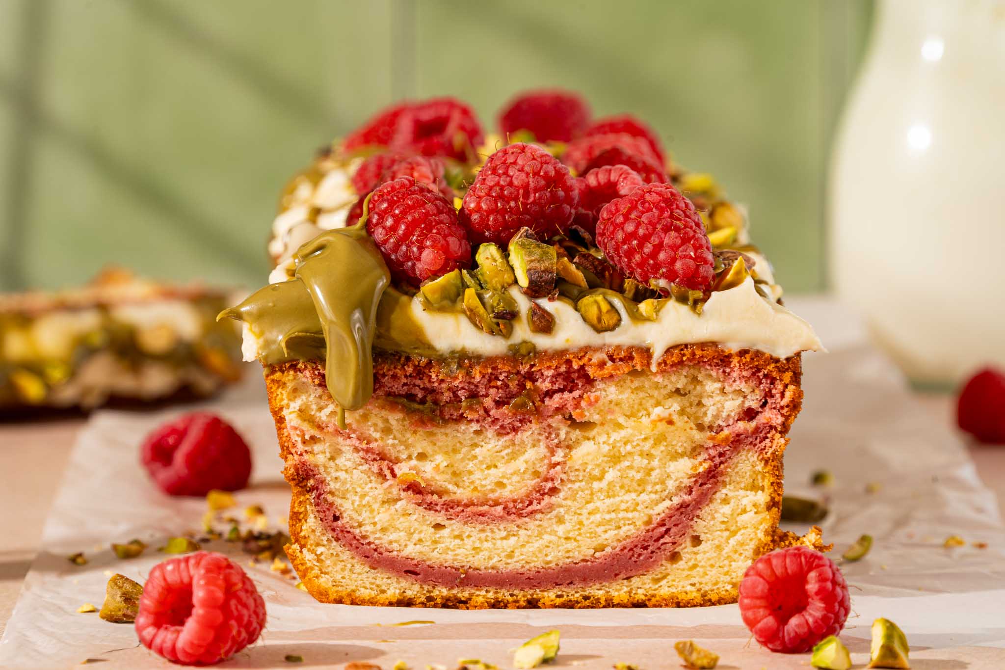 Pistache frambozen swirl kwarkcake met roomkaastopping, pistachepasta, verse frambozen en gehakte pistachenoten.