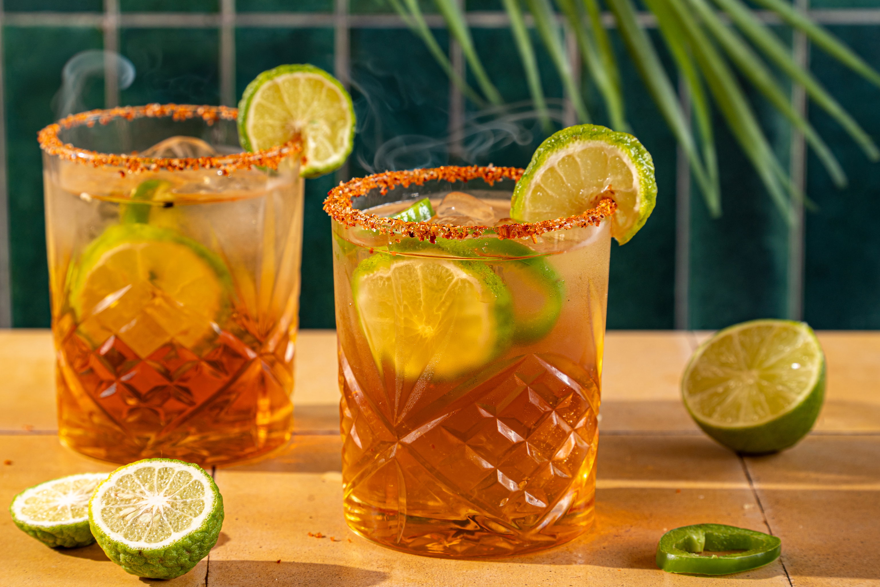 Smokey Sharp Cocktail met mezcal, jalapeño, kaffir limoen en tajínrand in een cocktailglas.