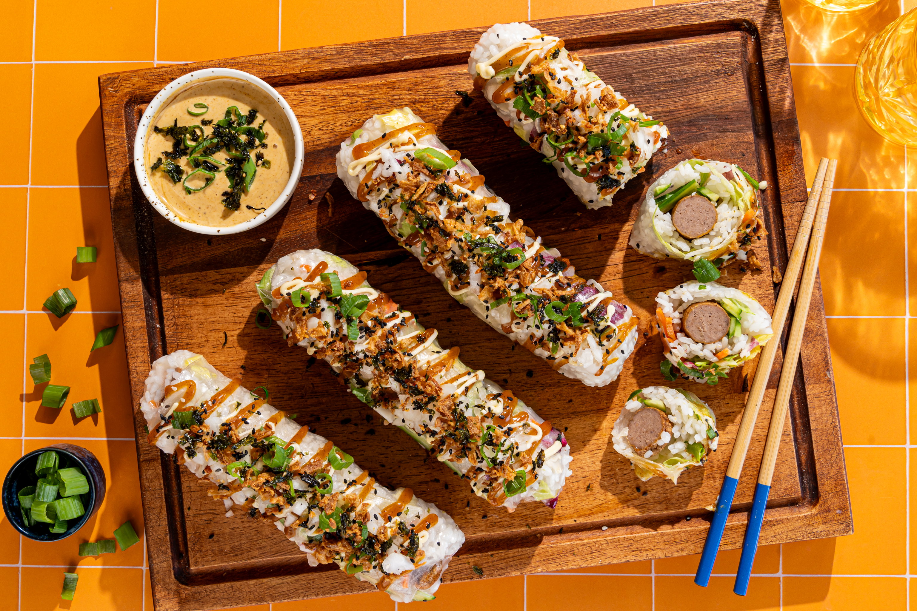 Frikandel sushi summer rolls met sushirijst, groenten, curry, Japanse mayonaise, gebakken uitjes en sesamzaadjes.