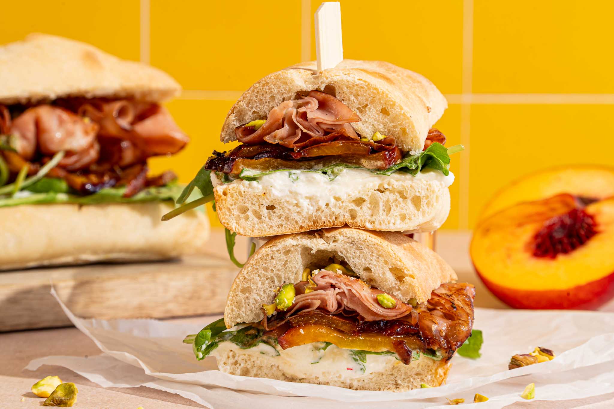 Italiaanse ciabatta met burrata, crispy mortadella, gebakken nectarine, rucola, pistachenoten en hot honey.