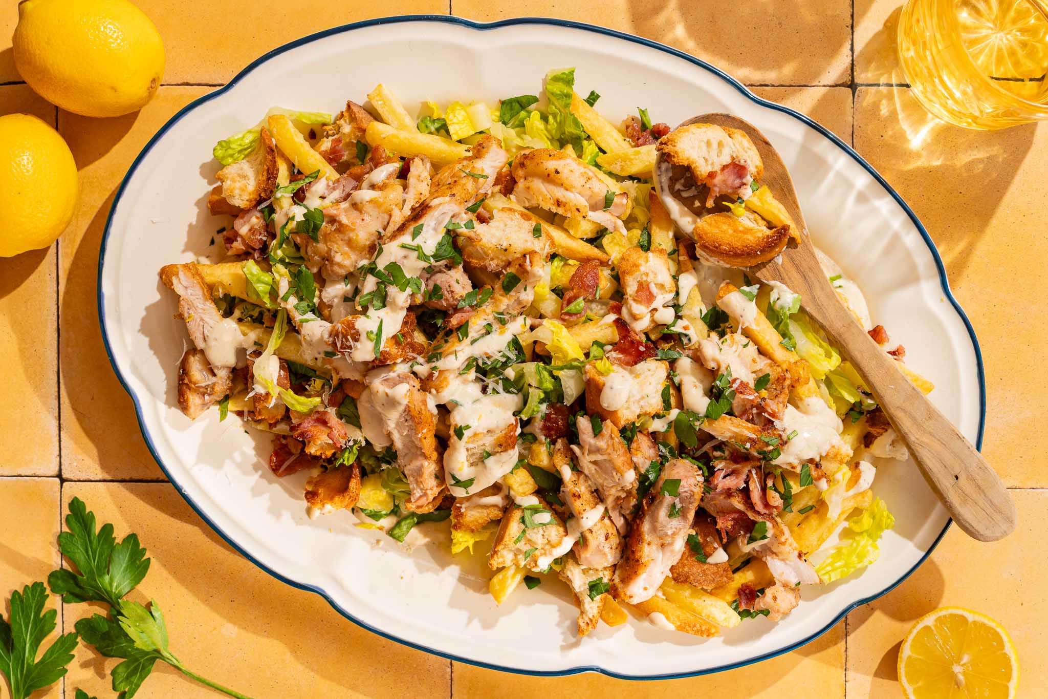 Caesar salad loaded fries met krokante friet, romaine sla, kippendij, bacon, Parmezaanse kaas, croutons en Caesardressing.