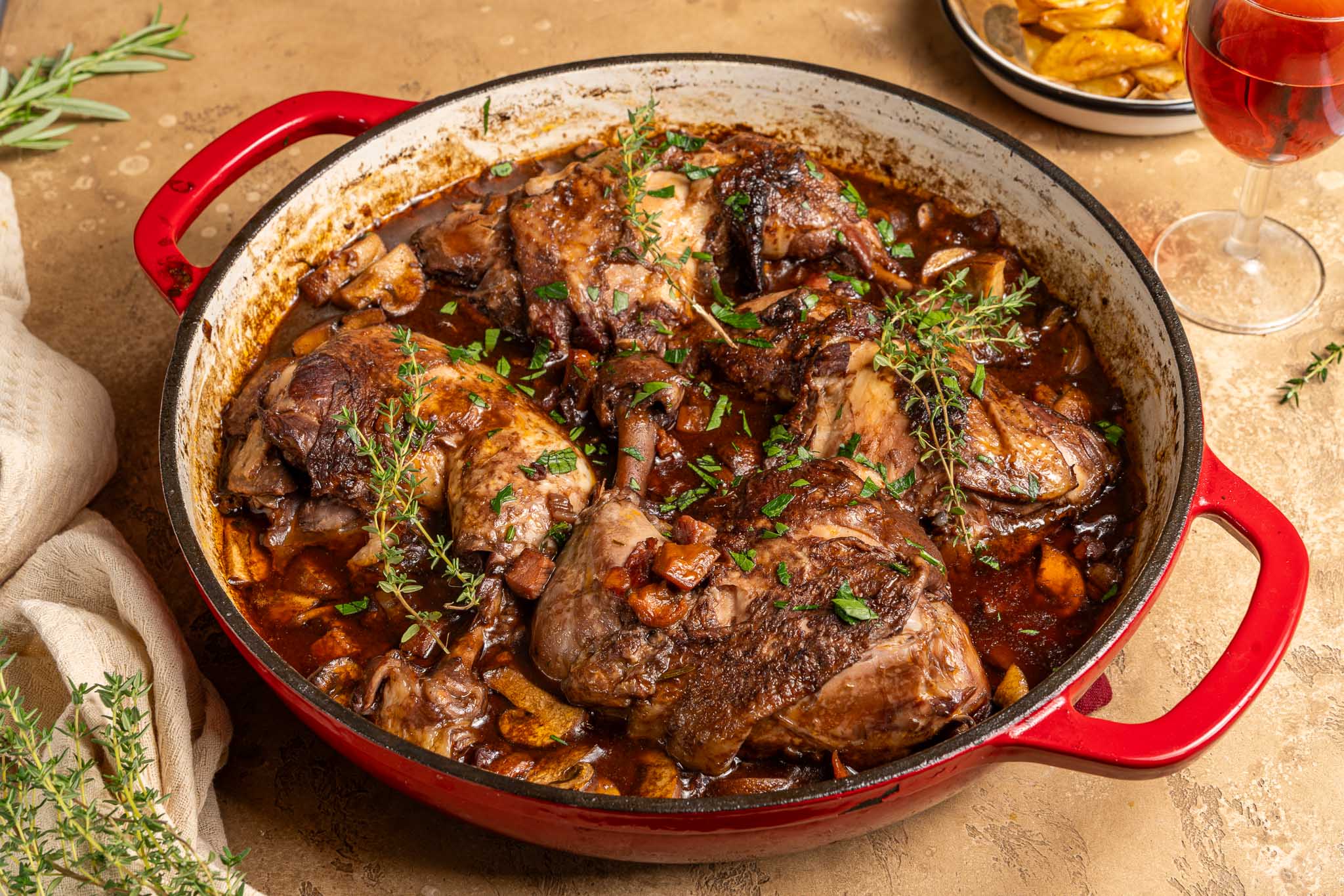 Franse coq au vin met gestoofde kip, rode wijn, spek, sjalot, wortel, champignons en verse peterselie.