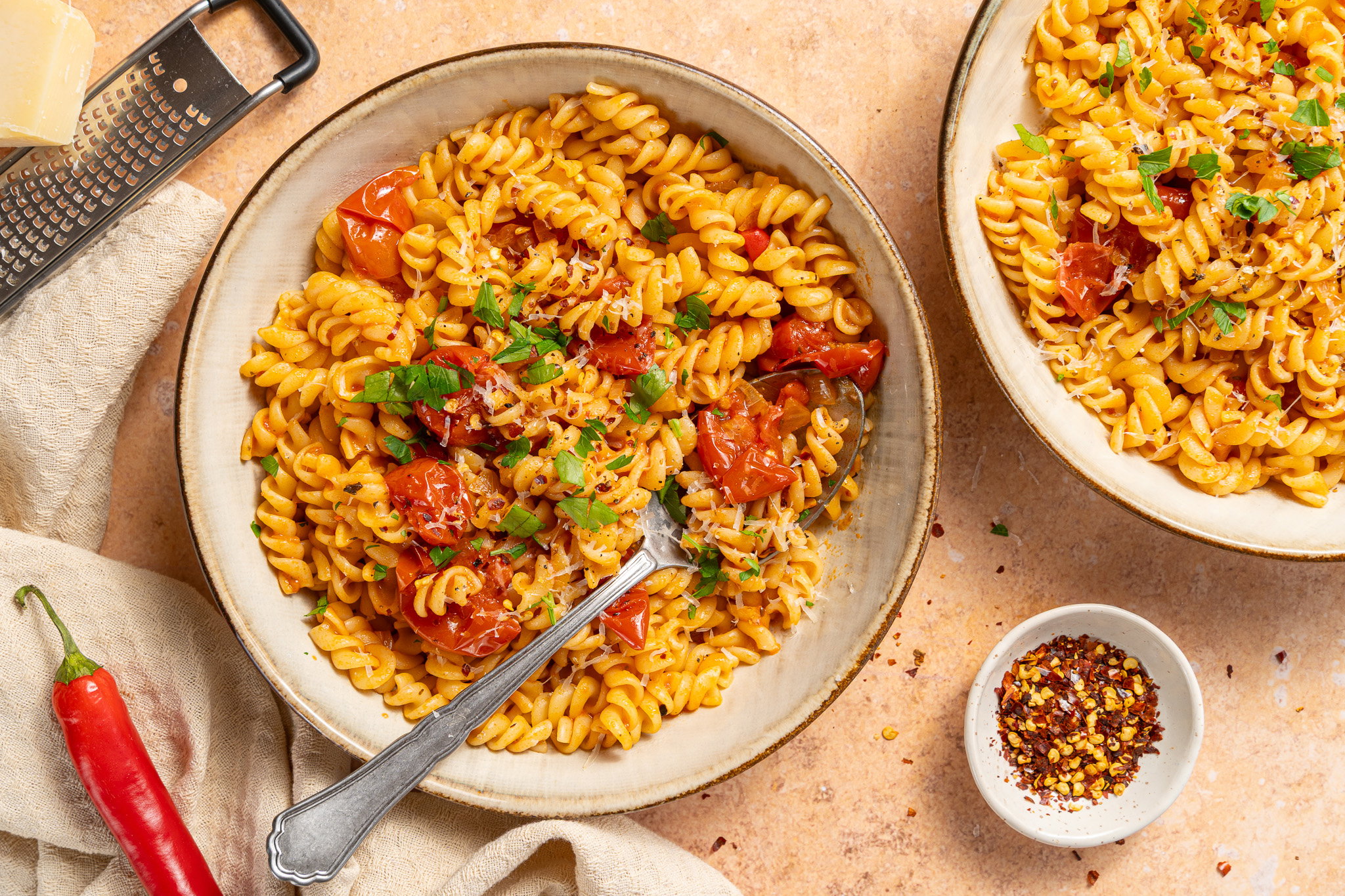 Pasta arrabbiata met fusilli, pittige tomatensaus, Parmezaanse kaas en verse peterselie.