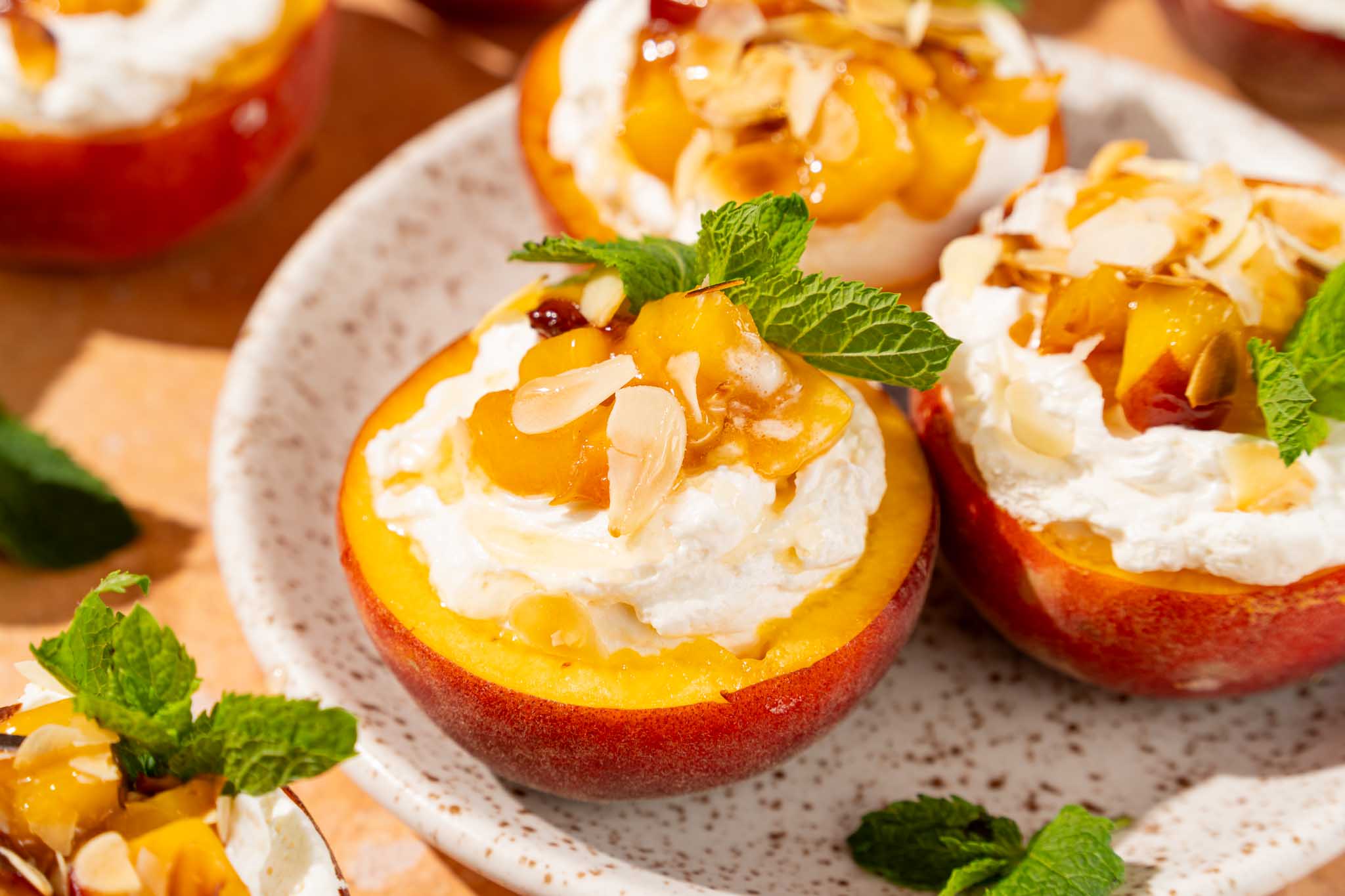 Peaches & cream met perzik gevuld met mascarponeroom, gekaramelliseerde perzik, amandelschaafsel en verse munt.