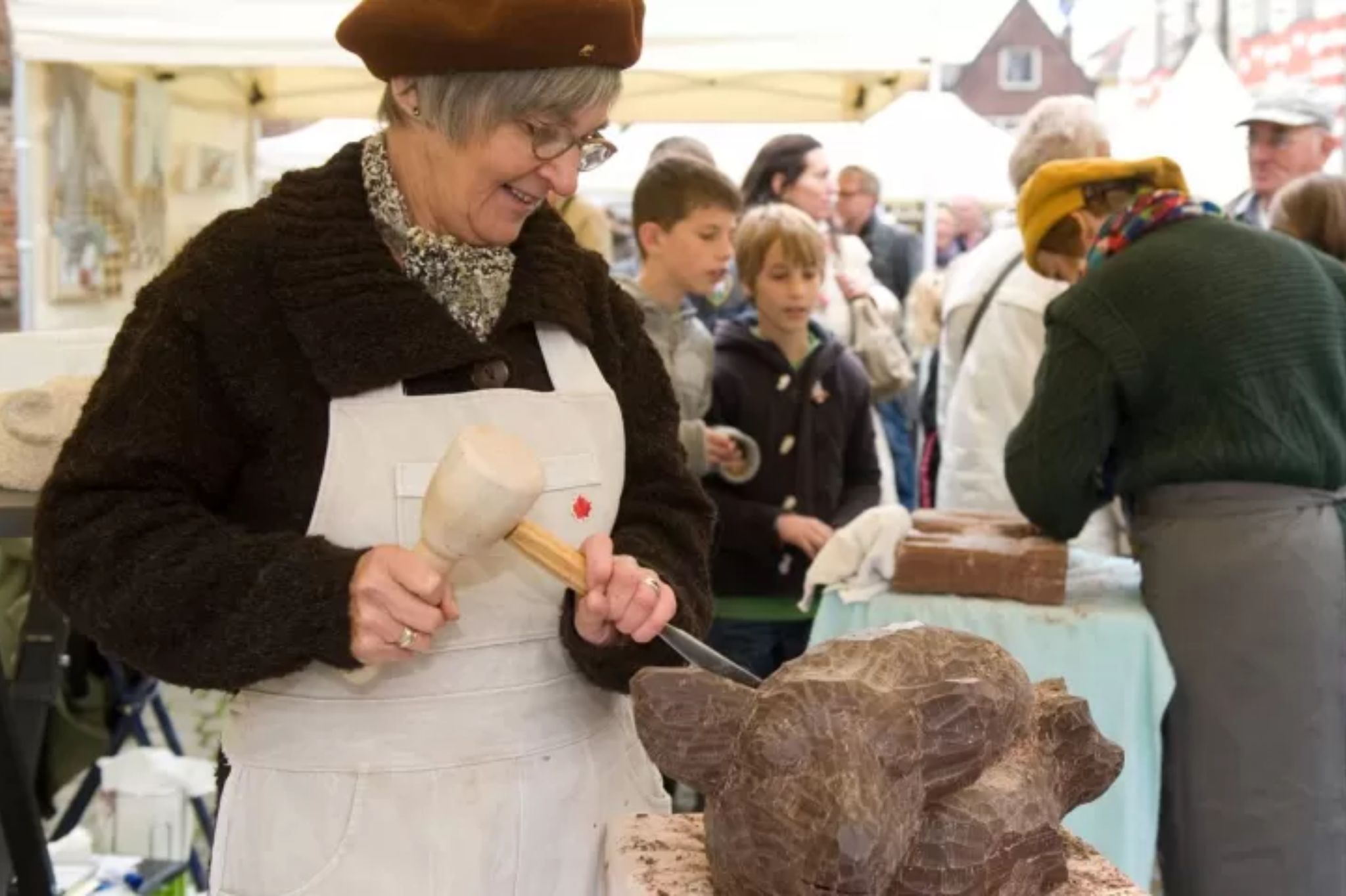Vrouw bewerkt chocolade op Chocoladefestival Hattem
